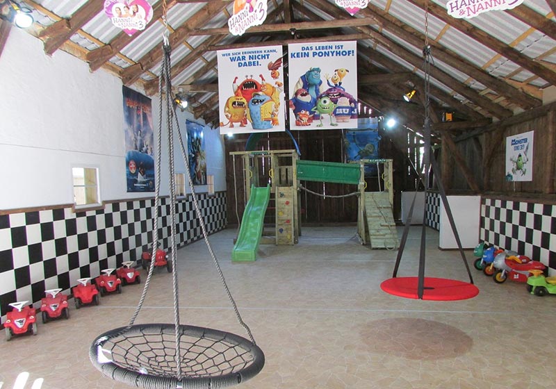 Hängenetze und Kletterturm in der Indoor-Spielscheune