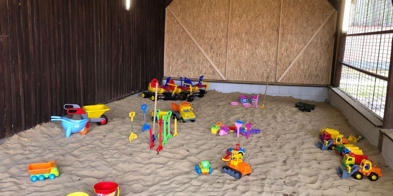 Überdachter Sandkasten mit Sandspielzeug