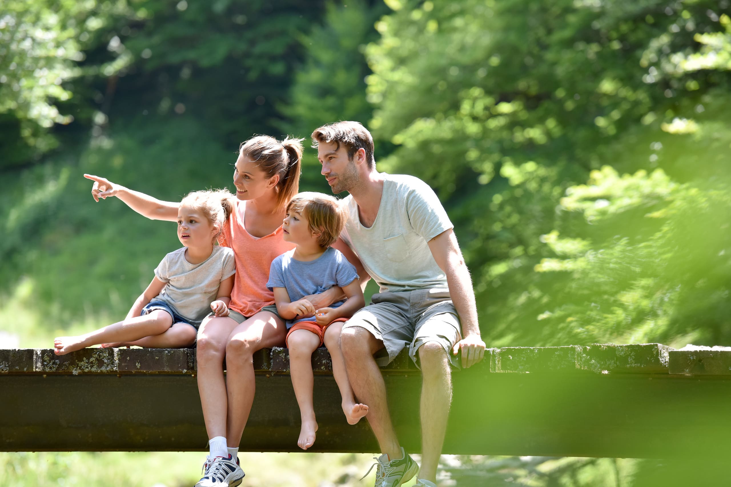Familie mit zwei Kindern sitzt auf Steg