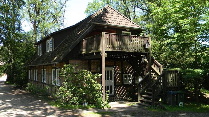 Gästehaus mit Ferienwohnungen, großem Holzbalkon und Gartenseite im Grünen