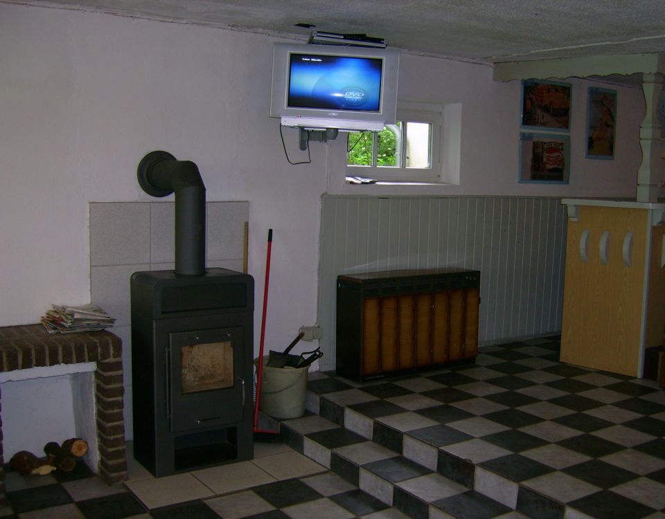 Raum mit Kaminofen und TV